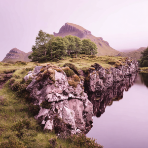 Rocky outcrop overlooking a still lake and distant mountain