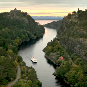 Scenic fjord with a passenger boat at sunset water